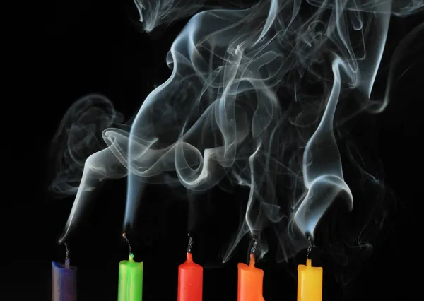 Cinco velas apagadas de color sobre fondo negro — Foto de Stock