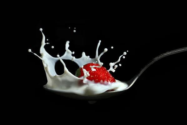 stock image Strawberry splashing into milk in the spoon