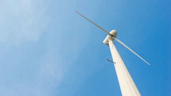 stock image White wind turbine on blue sky