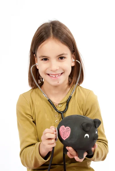 Little girl with stethoscope and piggy bank — Stock Photo, Image