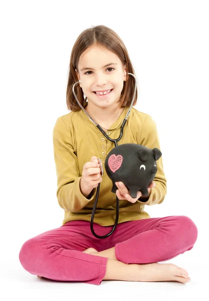 Dziewczynka z stetoskop i piggy bank — Zdjęcie stockowe