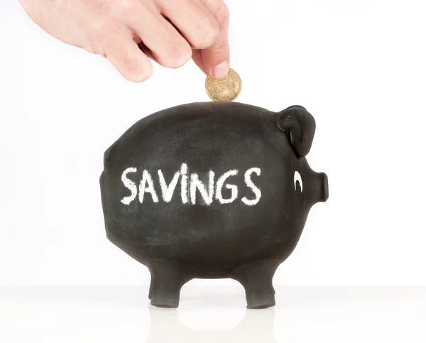 Putting a coin on a piggy bank — Stock Photo, Image