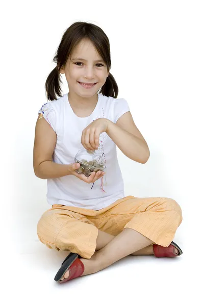 Dziewczynka oddanie pieniędzy do skarbonka — Zdjęcie stockowe