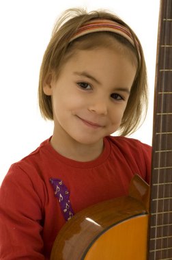 Küçük kız akustik gitar çalıyor.