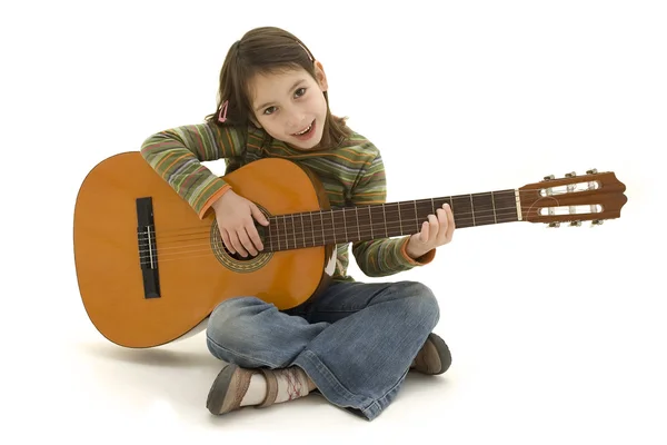 Молодая девушка играет на акустической гитаре — стоковое фото