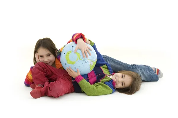 Két gyermek ölelni a földgömbön — Stock Fotó
