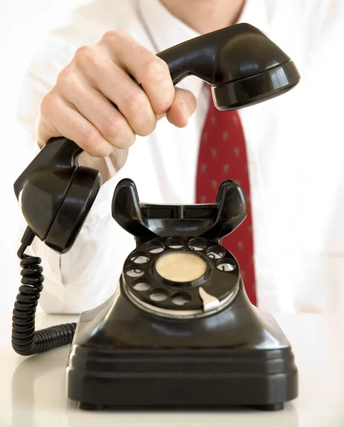 Holding an old black telephone — Stock Photo, Image