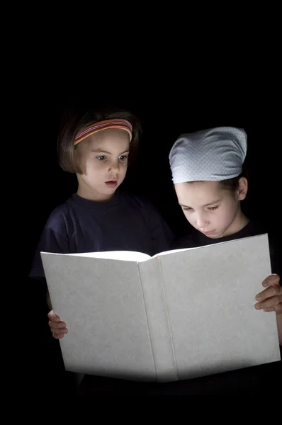 Twee meisjes die een boek lezen — Stockfoto
