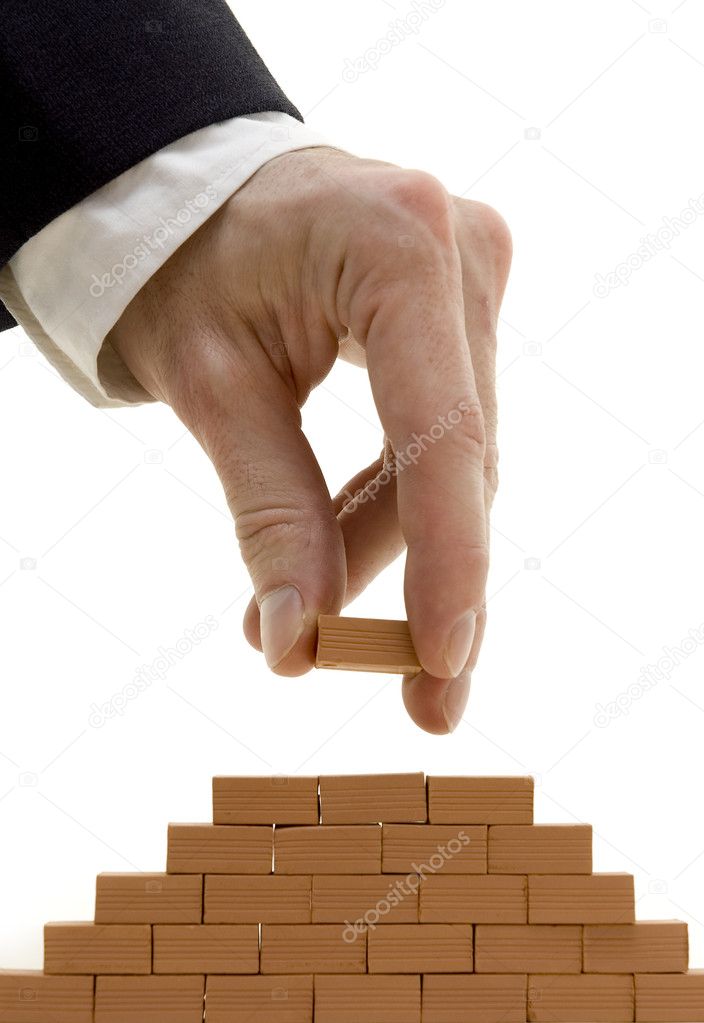 Businessman building a bricks wall