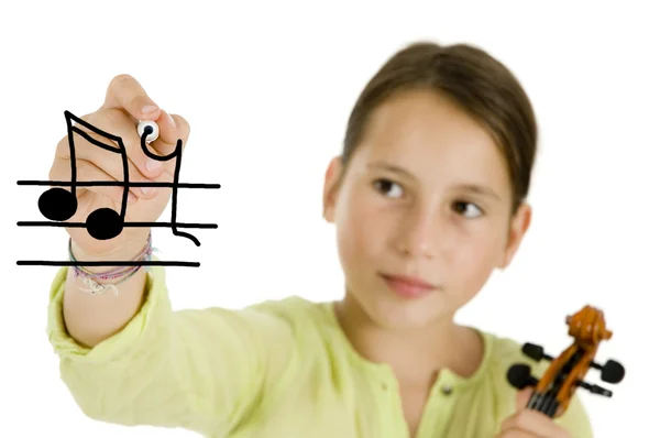 Young girl writing with a pen and holding a violin — Stock Photo, Image