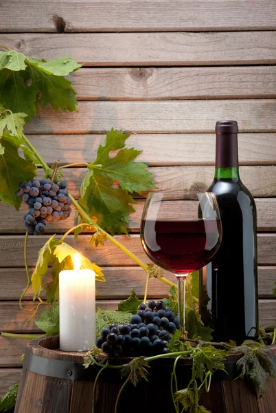 Red wine bottle with a candle — Stock Photo, Image