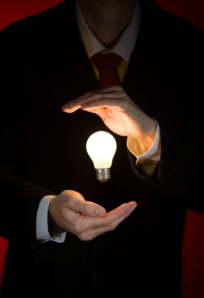Holding a light bulb Stock Image