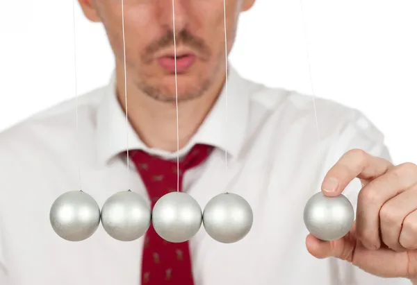 Businessman holding a pendulum ball — Stock Photo, Image