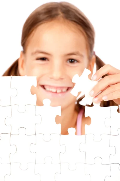 Маленькая девочка собирает головоломку — стоковое фото