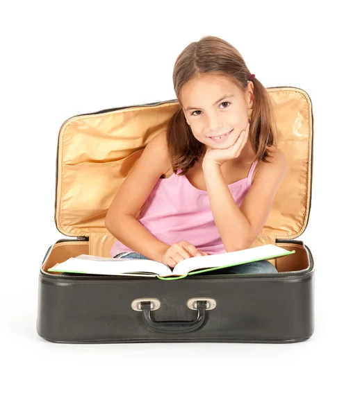 stock image Little girl inside a suitcase reading a book