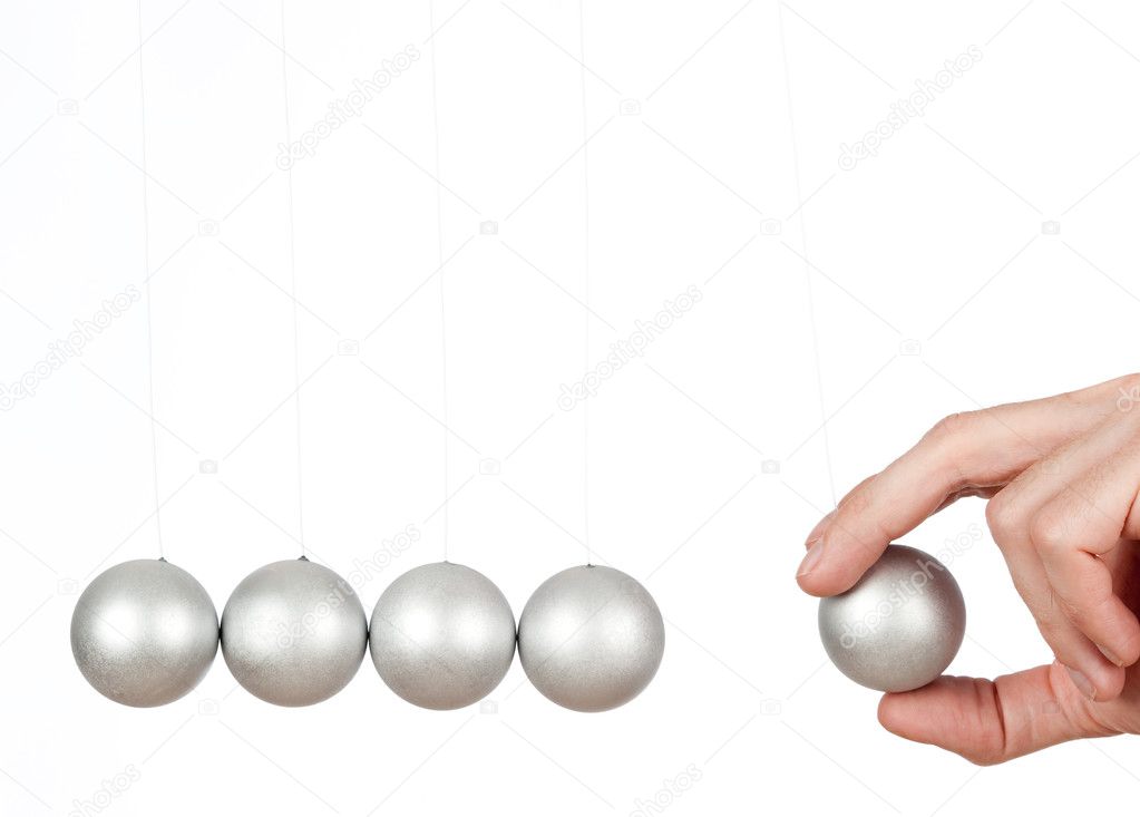 Hand holding a pendulum ball