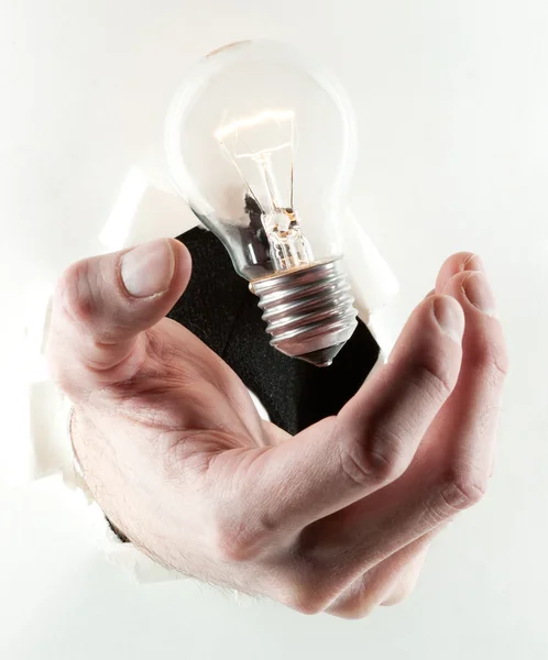 Light bulb in a paper hole — Stock Photo, Image