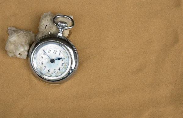 Reloj antiguo en fondo de arena — Foto de Stock