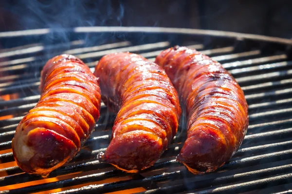 Close-up of three sausages on the grill — Stock Photo, Image