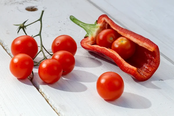 Fresh tomatoes and peppers on a board in the garden — Stock Photo, Image