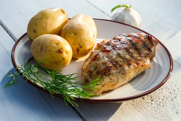 Roasted chicken served with potatoes and dill — Stock Photo, Image