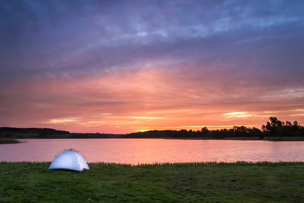 Vitt tält och stigande solen på sjön — Stockfoto