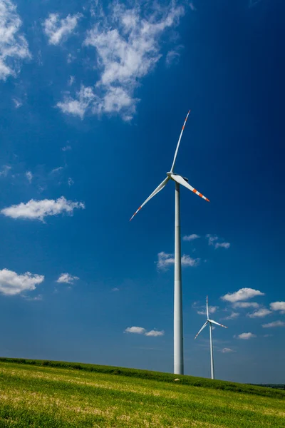 Turbiny wiatrowe na zielone pole z błękitnego nieba — Zdjęcie stockowe