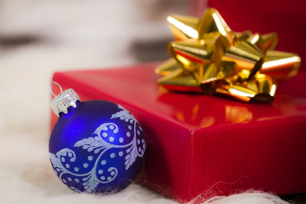 Голубая лампочка Рождества и красный подарок на белом фоне — стоковое фото