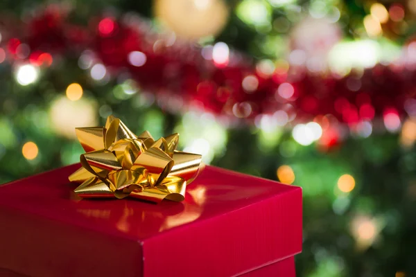 De gift van Kerstmis op kerstboom achtergrond openen — Stockfoto