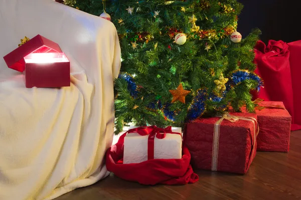 Presente aberto com luz de Natal no fundo da árvore de Natal — Fotografia de Stock
