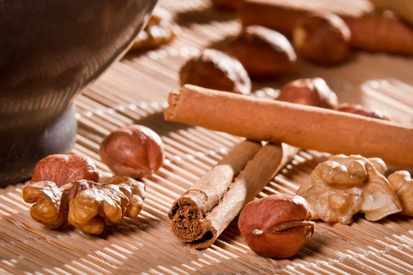Closeup all sorts of nuts on wooden bamboo mat — Stock Photo, Image