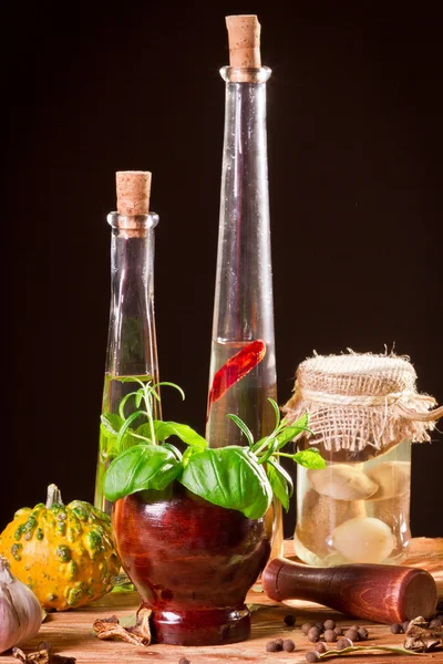 Flasche mit Pflanzenöl und frischen Gewürzen im Holzregal — Stockfoto