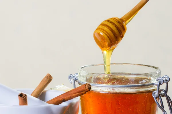 Honey dipper with jar on white background — Stock Photo, Image