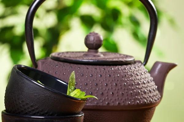 Bollitore e primo piano foglie di menta fresca in una tazza di tè — Foto Stock