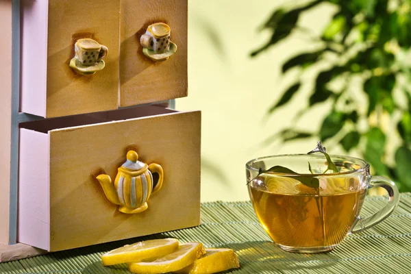 Te skåp och varmt te och citron — Stockfoto