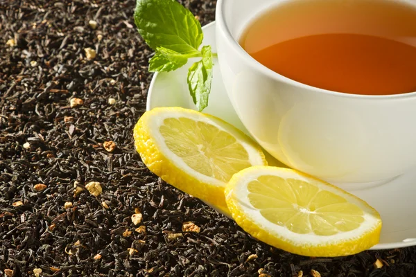 Hot cup of tea with lemon on grain background — Stock Photo, Image