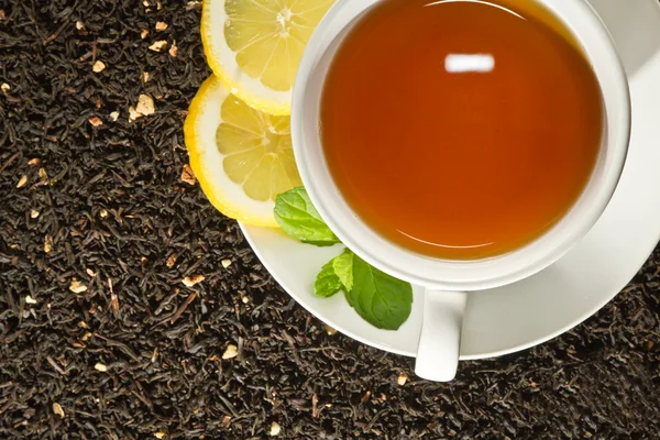 Tazza calda di tè e foglie fresche sullo sfondo del grano — Foto Stock