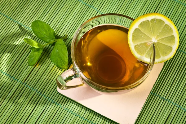 Filiżankę gorącej herbaty z cytryną na mat bambusowych — Zdjęcie stockowe