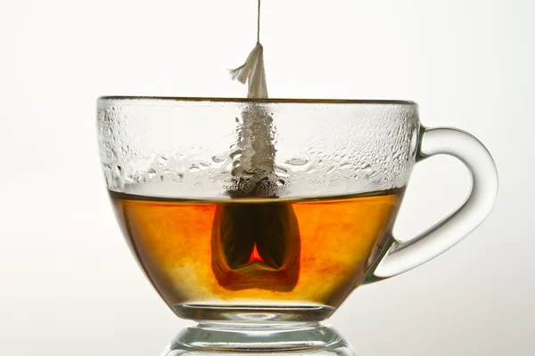 Teabag in una tazza piena di acqua calda isolata su backgrou bianco — Foto Stock