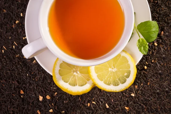 Tè al limone e foglie fresche su fondo di grano — Foto Stock