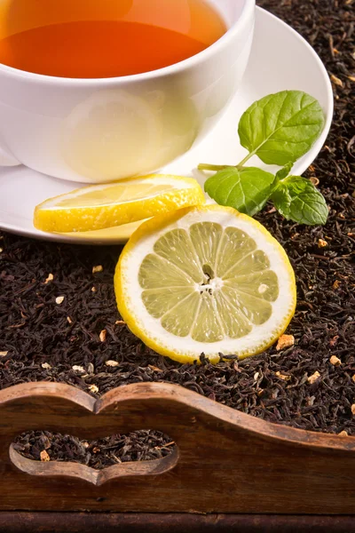 stock image Hot tea and fresh mint leaves on old wooden tray