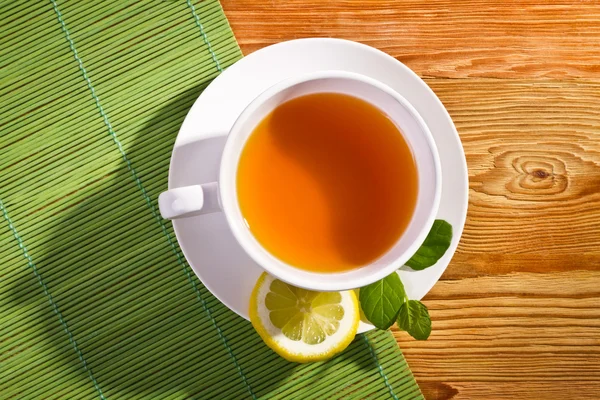 Tè caldo e limone su tappetino di bambù — Foto Stock