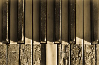 Closeup broken piano keys in sepia toned clipart