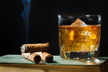 Tree cigar and whisky with ice in glass clipart