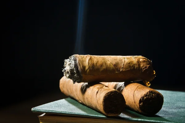 Tree cigars laying on leather book — Stock Photo, Image