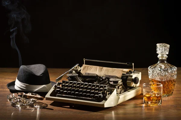 Retro-Styled velha máquina de escrever, charuto, chapéu e uísque com carafe — Fotografia de Stock