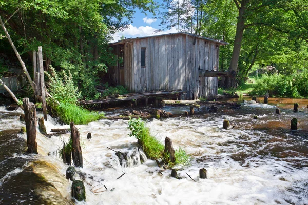 Oude gebroken molen in de buurt van de rivier in de zomer — Stockfoto