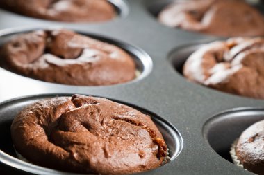 Closeup chocolate muffin in baking tray clipart