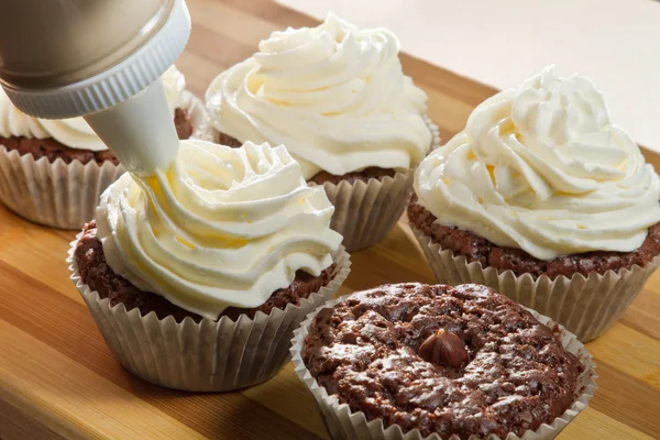 Décorer le muffin au chocolat avec de la crème vanille — Photo