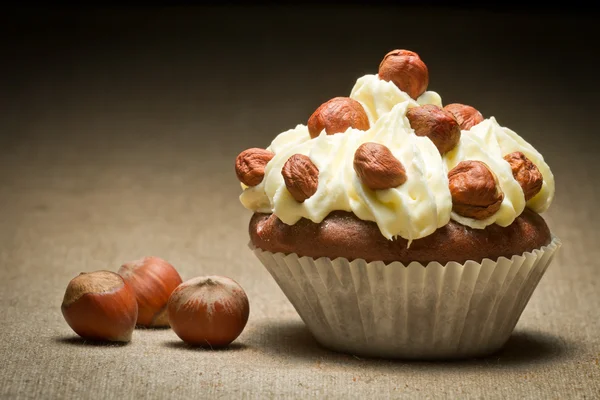 Muffin with vanilla cream and hazelnuts — Stock Photo, Image